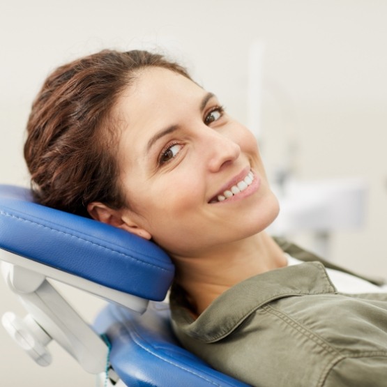 Smiling woman leaning back in dental chair