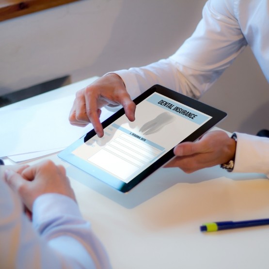 Two people looking at dental insurance information on a tablet