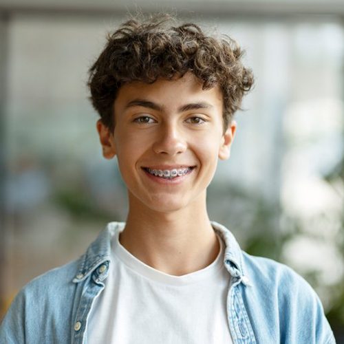 a young man smiling with traditional braces