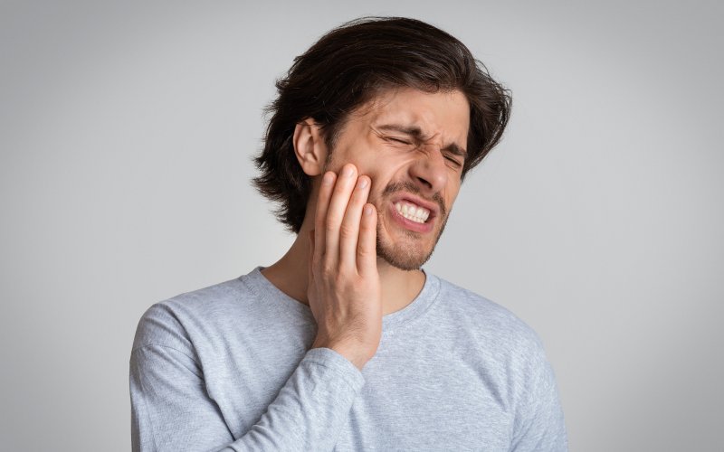 A grimacing man suffering from very strong tooth pain